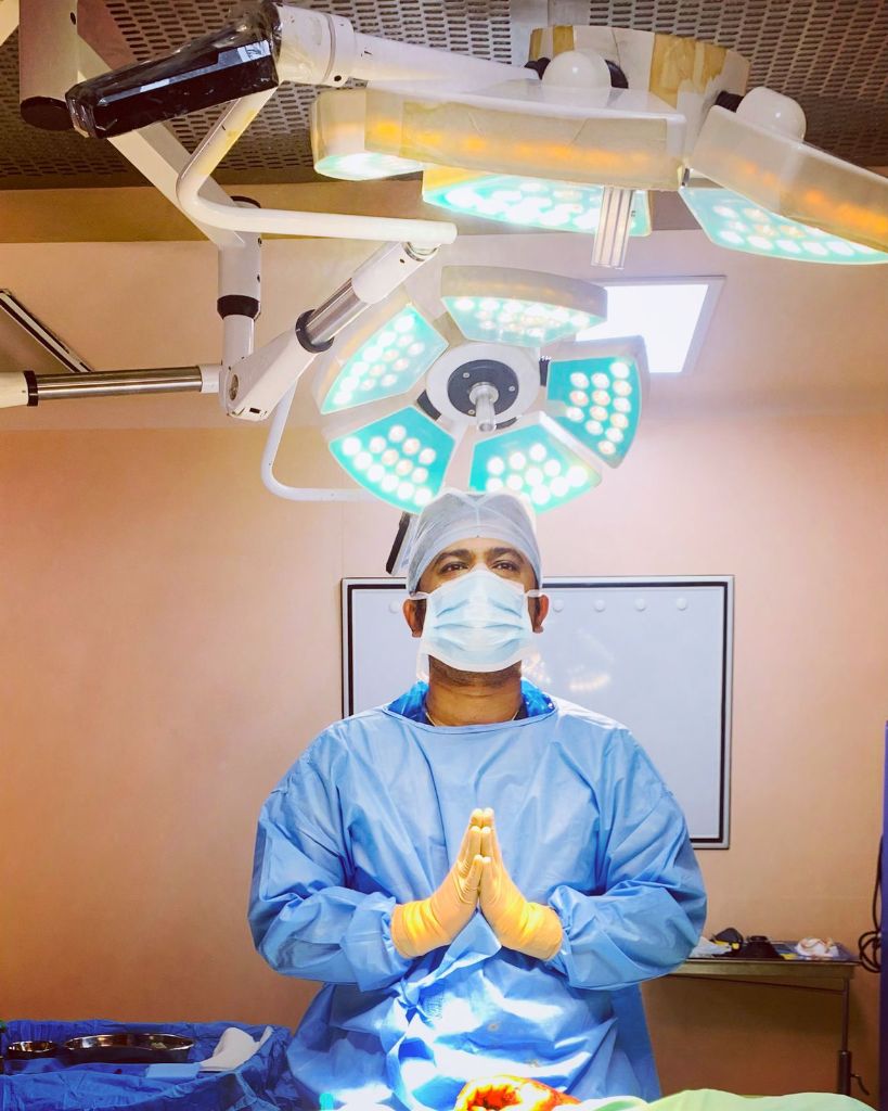 Dr. Karan Shetty - Board Certified Plastic Surgeon in surgical attire